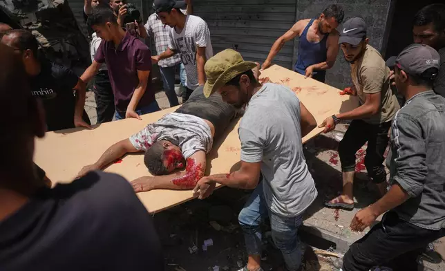 EDS NOTE: GRAPHIC CONTENT - Palestinians evacuate an injured man following an Israeli military strike, in Deir al-Balah, central Gaza Strip, Saturday, July 25, 2026. (AP Photo/Abdel Kareem Hana)