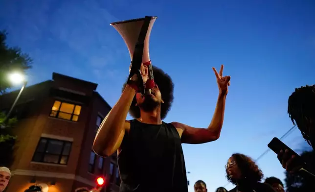 An attendee speaks at a candlelight vigil where a Madison police officer shot and killed a man Wednesday, July 22, 2026, in Madison, Wis. (AP Photo/Kayla Wolf)