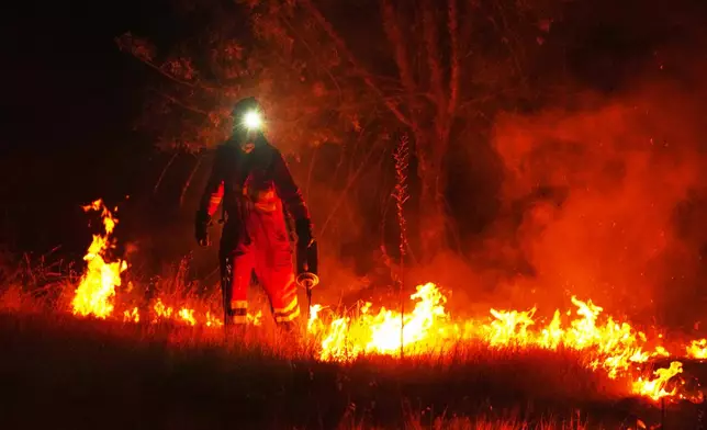 Firefighters use controlled burning to halt a wildfire that continues to spread near Cebreros, Ávila province, Spain, Tuesday, July 28, 2026. (AP Photo/Manu Fernandez)