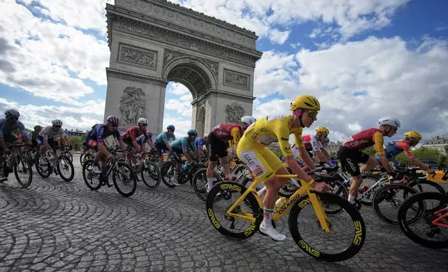 Slovenia's Tadej Pogacar, wearing the overall leader's yellow jersey, rides past the Arc de Triomphe during the last stage of the Tour de France cycling race with start and finish in Paris, Sunday, July 26, 2026. (AP Photo/Mosa'ab Elshamy)
