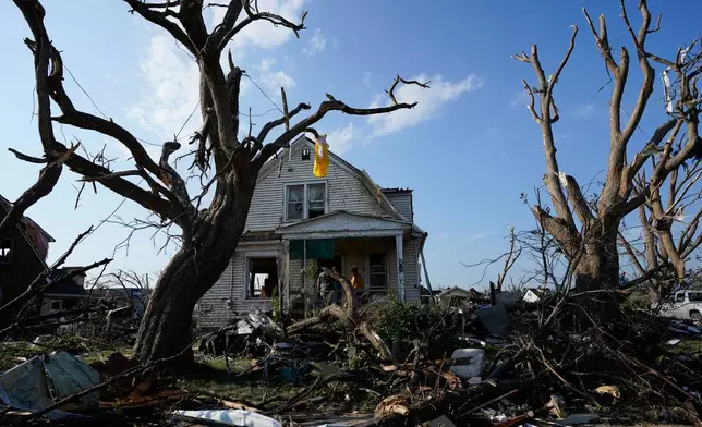 Debris is seen in front of a damaged house after a tornado struck Monday, July 27, 2026, in Menasha, Wis. (AP Photo/Kayla Wolf)