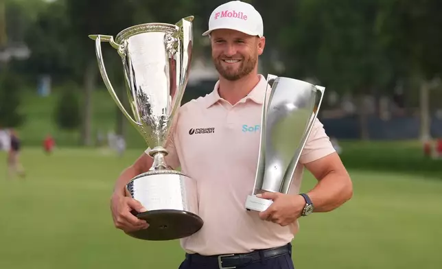Wyndham Clark holds the Wanamaker Trophy and the BMW trohy after winning the BMW Championship golf tournament, Sunday, Aug. 23, 2026, in St. Louis. (AP Photo/Jeff Roberson)