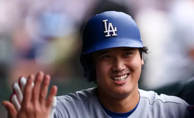 Los Angeles Dodgers designated hitter Shohei Ohtani celebrates in the dugout with teammates after hitting a home during the first inning of a baseball game against the Chicago Cubs in Chicago, Wednesday, Aug. 5, 2026. (AP Photo/Jessie Alcheh)