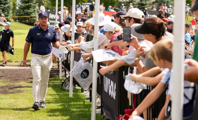 Captain Bryson DeChambeau, left, of Crushers GC, greets fans before the final round of LIV Golf Indianapolis, Sunday, Aug. 23, 2026, in Westfield, Ind. (Pedro Salado/LIV Golf via AP)