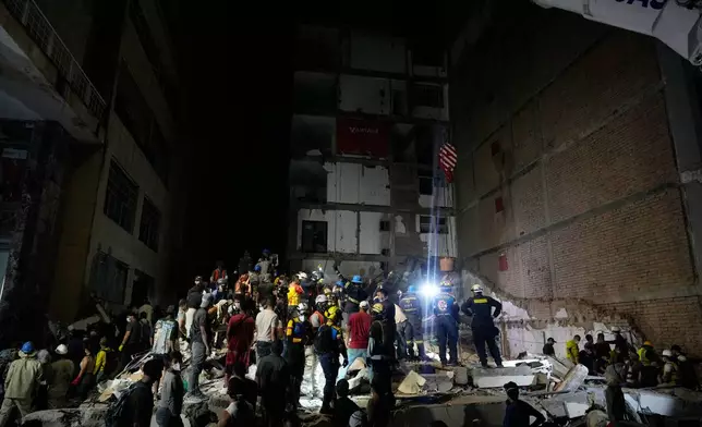 Rescue workers and residents search through the rubble after an earthquake struck Pereira, Colombia, Monday, Aug. 10, 2026. (AP Photo/Fernando Vergara)