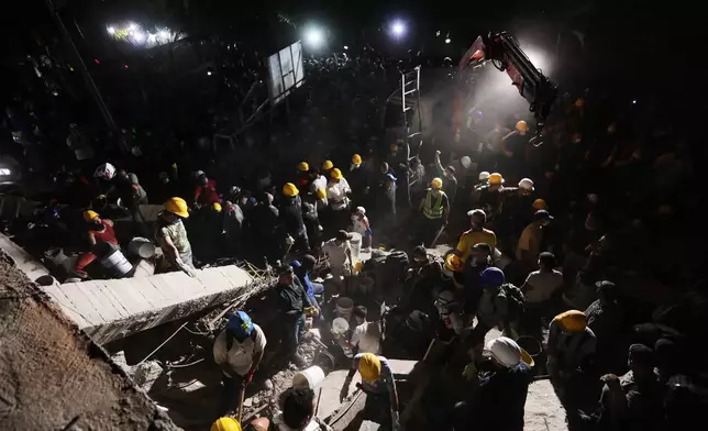 Rescue workers and residents search through the rubble after an earthquake struck Cali, Colombia, Monday, Aug. 10, 2026. (AP Photo/Santiago Saldarriaga)