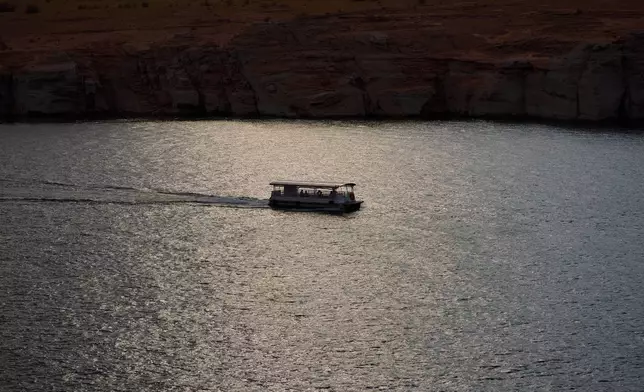 People boat on Lake Powell at the Glen Canyon National Recreation Area, Tuesday, July 14, 2026, near Page, Nev. (AP Photo/John Locher)