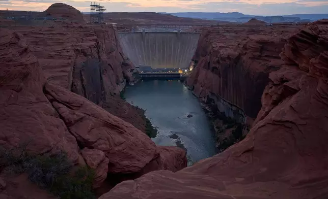 The Colorado River flows beneath the Glen Canyon Dam at the Glen Canyon National Recreation Area, Tuesday, July 14, 2026, near Page, Nev. (AP Photo/John Locher)