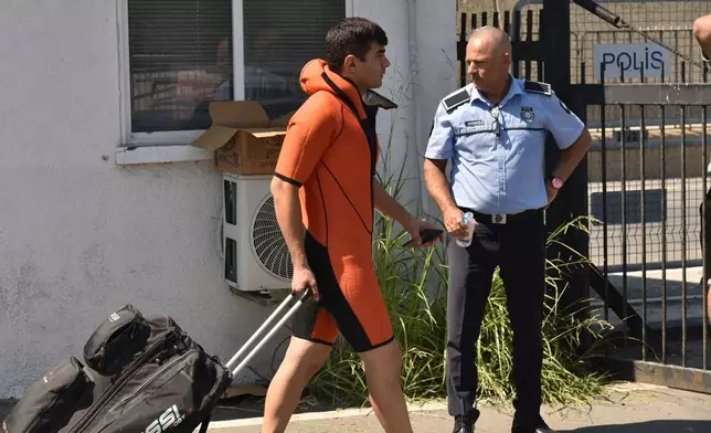 A survivor of a catamaran-style ferry which was capsized off the coast of northern Cyprus, arrives at the port of Kyrenia in the Turkish occupied northern part of Cyprus, Sunday, Aug. 30, 2026. (AP Photo) CORRECTION: a man instead of a survivor