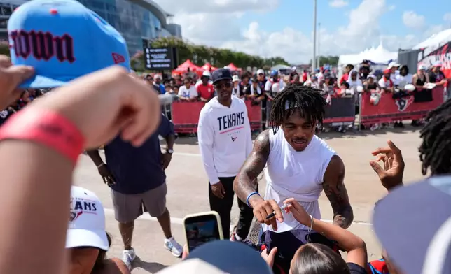 Houston Texans wide receiver Tank Dell greets fans during "Back Together Weekend" at the team's NFL football training camp in Houston, Saturday, August 1, 2026. (AP Photo/Ashley Landis)
