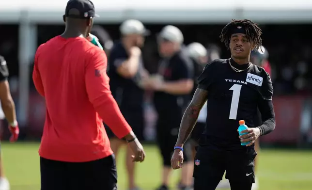 Houston Texans wide receiver Tank Dell (1) greets head coach DeMeco Ryans during the team's NFL football training camp in Houston, Friday, August 7, 2026. (AP Photo/Ashley Landis)