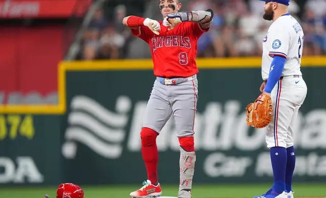 Los Angeles Angels' Zach Neto (9) reacts from second base next to Texas Rangers first baseman Jake Burger (21) after hitting a double during the first inning of a baseball game, Saturday, Aug. 22, 2026, in Arlington, Texas. (AP Photo/LM Otero)