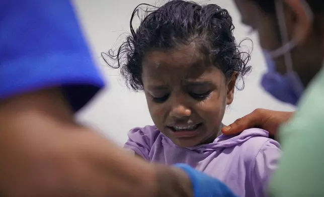 An injured child receives treatment at a hospital after a strike on the port of Mokha, Yemen, Friday, Aug. 14, 2026. (AP Photo/Abdulnasser Alseddik)