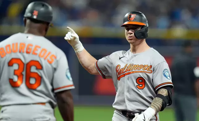 Baltimore Orioles' Tyler O'Neill (9) celebrates with first base coach Jason Bourgeois (36) after his RBI single off Tampa Bay Rays pitcher Bryan Baker during the 10th inning of a baseball game Saturday, Aug. 15, 2026, in St. Petersburg, Fla. (AP Photo/Chris O'Meara)