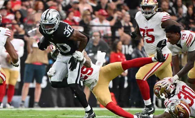 San Francisco 49ers safety Ashtyn Davis (29) tackles Las Vegas Raiders running back Mike Washington Jr. (30) as San Francisco 49ers linebacker Jaden Dugger (53) loses his helmet during the first half of an NFL preseason football game, Thursday, Aug. 27, 2026}, in Las Vegas. (AP Photo/David Becker)