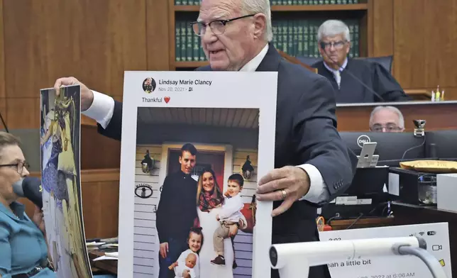 Defense attorney Kevin Reddington holds up a picture of th Clancy family before the murders during closing arguments in the Lindsay Clancy murder trial at Plymouth Superior Court in Plymouth, Mass., Thursday, Aug. 27, 2026. (Greg Derr/The Patriot Ledger via AP, Pool)