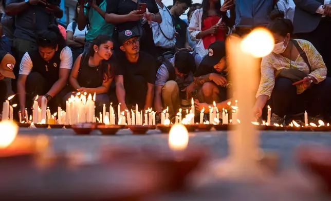 Family members, friends and supporters light candles in memory of the climbers who died Thursday in an avalanche on Pakistan's Broad Peak, Kathmandu, Nepal, Tuesday, Aug. 4, 2026. (AP Photo/Niranjan Shrestha)