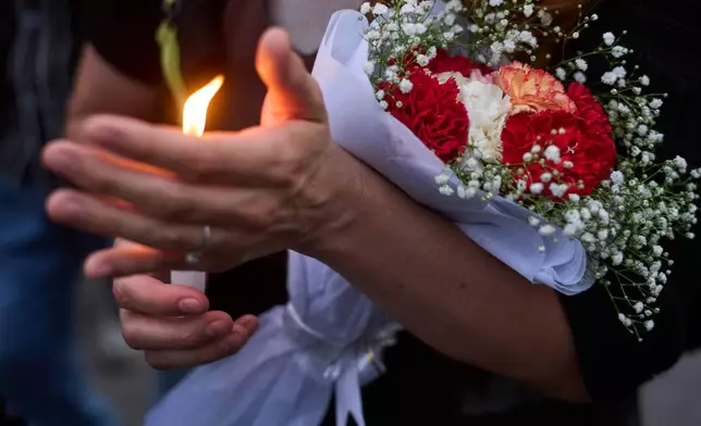A woman lights candle in memory of the climbers who died Thursday in an avalanche on Pakistan's Broad Peak, Kathmandu, Nepal, Tuesday, Aug. 4, 2026. (AP Photo/Niranjan Shrestha)