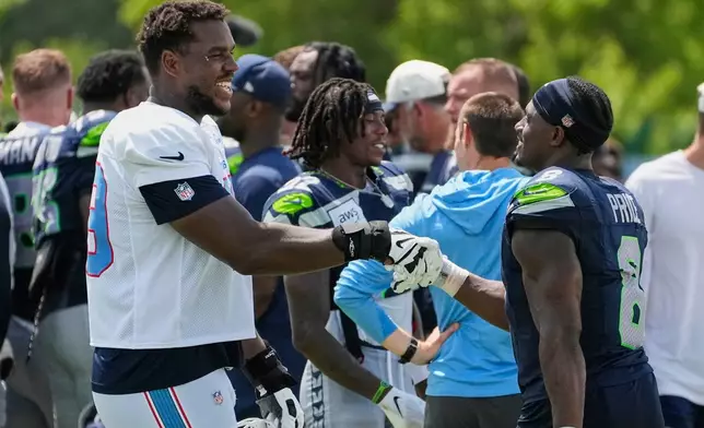 Tennessee Titans tackle Aamil Wagner, left, greets Seattle Seahawks running back Jadarian Price, right, after a joint NFL football practice Friday, Aug. 21, 2026, in Nashville, Tenn. (AP Photo/George Walker IV)