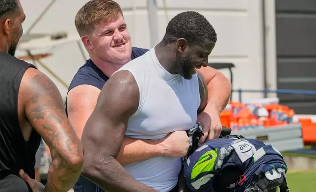 Seattle Seahawks guard Grey Zabel, left, hugs Tennessee Titans defensive end Oluwafemi Oladejo, right, after a joint NFL football practice Friday, Aug. 21, 2026, in Nashville, Tenn. (AP Photo/George Walker IV)