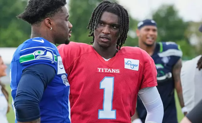 Tennessee Titans quarterback Cam Ward (1) talks to Seattle Seahawks quarterback Jalen Milroe, left, after a joint NFL football practice Friday, Aug. 21, 2026, in Nashville, Tenn. (AP Photo/George Walker IV)
