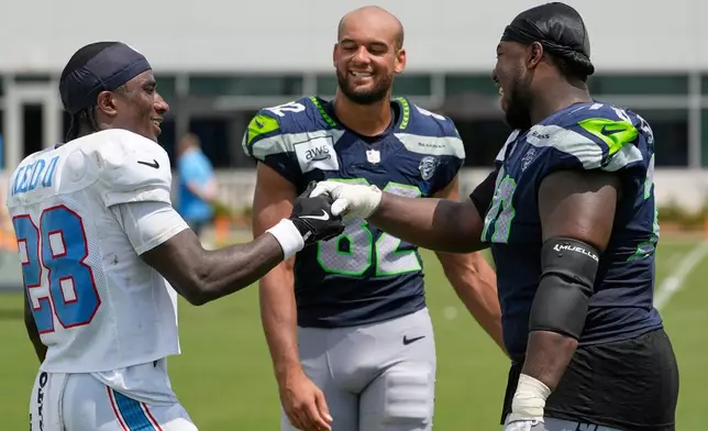 Tennessee Titans defensive back Jerrick Reed II (28) greets Seattle Seahawks wide receiver Cody White (82) and defensive tackle J.R. Singleton (70) after a joint NFL football practice Friday, Aug. 21, 2026, in Nashville, Tenn. (AP Photo/George Walker IV)