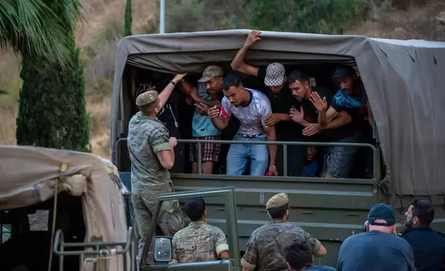 Migrants who crossed into Spain are escorted by Spanish soldiers towards the Spanish-Moroccan border for their return to Morocco from the Spanish enclave of Ceuta, Sunday, Aug. 2, 2026. (AP Photo/Antonio Sempere)