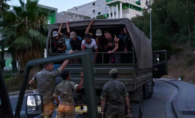 Migrants who crossed into Spain are escorted by Spanish soldiers towards the Spanish-Moroccan border for their return to Morocco from the Spanish enclave of Ceuta, Sunday, Aug. 2, 2026. (AP Photo/Bernat Armangue)