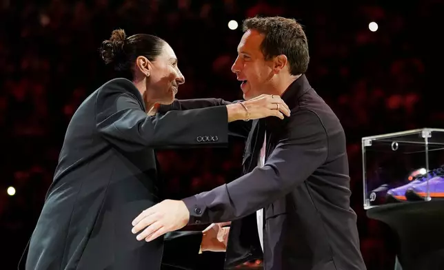 Retired Phoenix Mercury WNBA basketball player Diana Taurasi, left, hugs Phoenix Suns and Mercury owner Mat Ishbia as Taurasi is honored during a halftime Ring of Honor ceremony Sunday, Aug. 16, 2026, in Phoenix. (AP Photo/Ross D. Franklin)