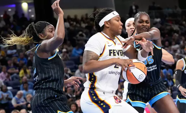 Indiana Fever forward Myisha Hines-Allen, center, battles for the ball against Chicago Sky center-forward Elizabeth Williams, left, and Aicha Coulibaly, right, during the first half of a WNBA basketball game Sunday, Aug. 23, 2026, in Chicago. (AP Photo/Nam Y. Huh)