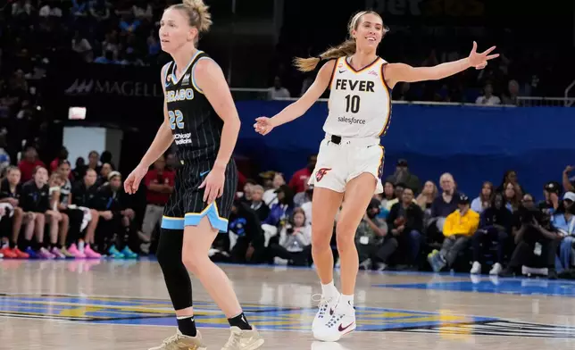 Indiana Fever guard Lexie Hull, right, reacts after scoring a 3-point basket as Chicago Sky guard Courtney Vandersloot, left, looks at a teammate during the first half of a WNBA basketball game Sunday, Aug. 23, 2026, in Chicago. (AP Photo/Nam Y. Huh)