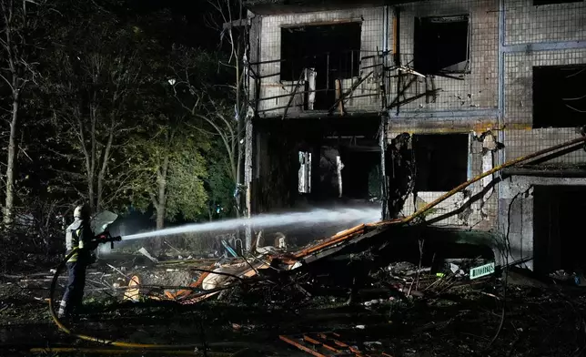 Emergency services personnel work to extinguish a fire following Russian missile attacks in Kyiv, Ukraine, Saturday, Aug. 1, 2026. (AP Photo/Efrem Lukatsky)