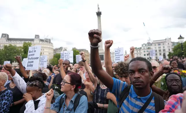 People gesture as they attend a vigil held by Stand Up to Racism, in memory of late University of Cambridge professor Jason Arday, in Trafalgar Square in London, Monday, Aug. 17, 2026. (AP Photo/Kirsty Wigglesworth)