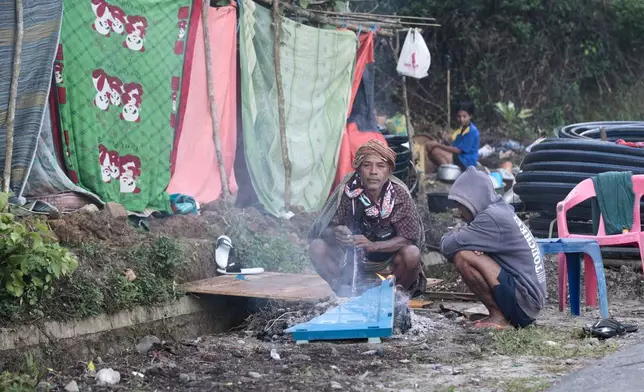 Earthquake survivors make fire to warm themselves outside their makeshift tent in Reo, East Nusa Tenggara province, Indonesia, Monday, Aug. 17, 2026. (AP Photo/Firdia Lisnawati)