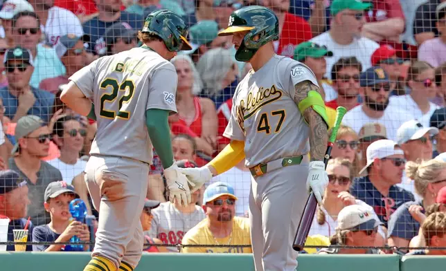 Athletics' Jeff McNeil (22) greetss teammate Tommy White (47) after scoring during the eighth inning of a baseball game against the Boston Red Sox, Sunday, Aug. 9, 2026, in Boston. (AP Photo/Mark Stockwell)