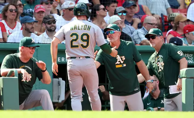 Athletics's Donovan Walton (29) is greeted at the dugout after scoring the winning run during the ninth inning of a baseball game against the Boston Red Sox, Sunday, Aug. 9, 2026, in Boston. (AP Photo/Mark Stockwell)