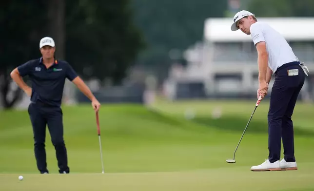 Ryan Gerard putts on the first green as Viktor Hovland, of Norway, looks on during the third round of the PGA Tour Championship golf tournament, Saturday, Aug 29, 2026, in Atlanta.(AP Photo/Mike Stewart)