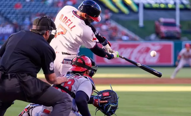 Los Angeles Angels' Jo Adell, center, hits a two-run home run as St. Louis Cardinals catcher Iván Herrera, right, and home plate umpire Mark Ripperger watch during the first inning of a baseball game Tuesday, July 21, 2026, in Anaheim, Calif. (AP Photo/Mark J. Terrill)