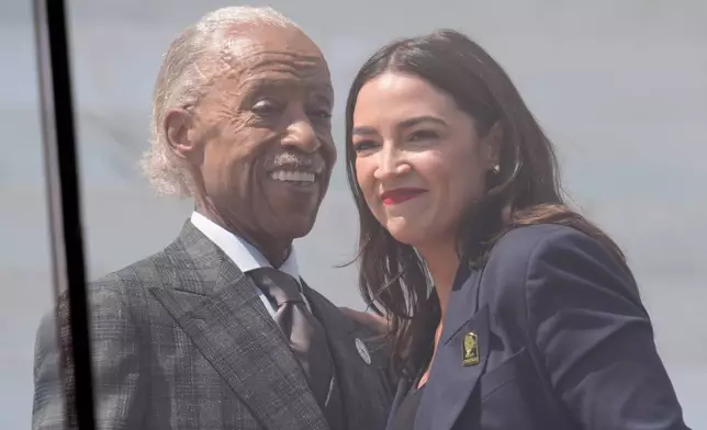 Rev. Al Sharpton, left, and Rep. Alexandria Ocasio-Cortez, D-N.Y, right, on stage together during the March on Washington rally at the Lincoln Memorial on the National Mall, Friday, Aug. 28, 2026 in Washington. (AP Photo/Manuel Balce Ceneta)
