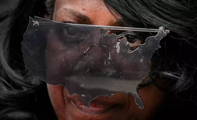 An activist wears United States-shaped sunglasses during the March on Washington, Friday, Aug. 28, 2026, in Washington. (AP Photo/Julia Demaree Nikhinson)