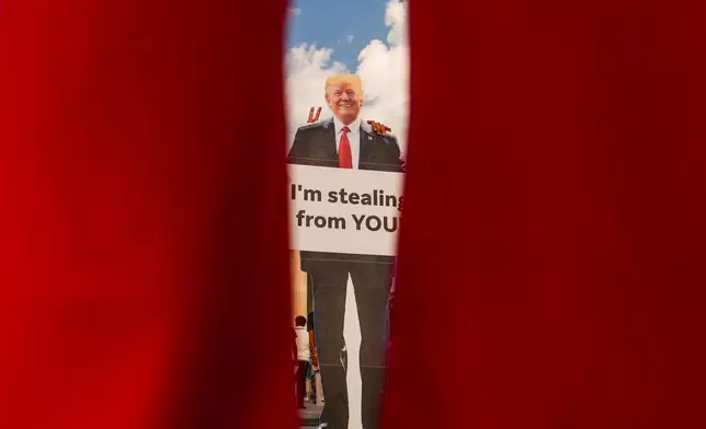 Demonstrators take photos with a cardboard cut out of President Donald Trump near the Lincoln Memorial before the March on Washington, Friday, Aug. 28, 2026, in Washington. (AP Photo/Julia Demaree Nikhinson)