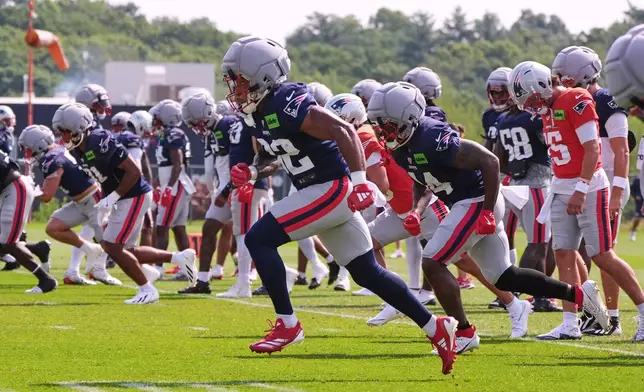 New England Patriots running back Treveyon Henderson, center, runs during a NFL football training camp, Tuesday, Aug. 11, 2026, in Foxborough, Mass. (AP Photo/Charles Krupa)