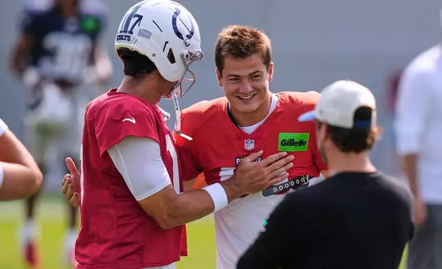 New England Patriots quarterback Drake Maye, right, greets Indianapolis Colts quarterback Daniel Jones (17) prior to a joint practice session at an NFL football training camp in Foxborough, Mass., Tuesday, Aug. 11, 2026. (AP Photo/Charles Krupa)