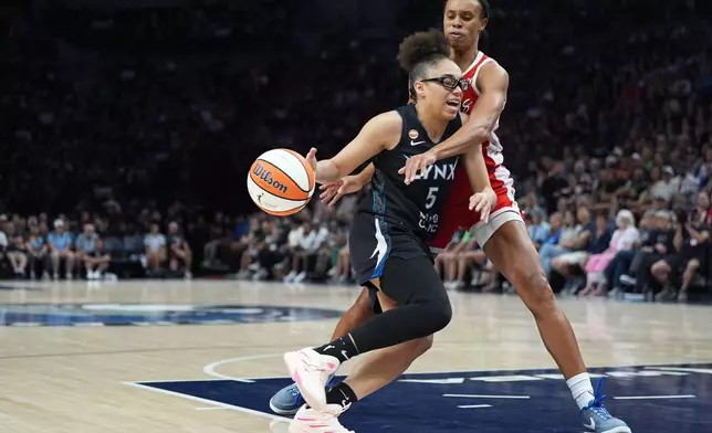Minnesota Lynx guard Olivia Miles works toward the basket as Las Vegas Aces forward Brianna Turner defends during the first half of a WNBA basketball game in Minneapolis, Saturday, Aug. 8, 2026. (AP Photo/Abbie Parr)