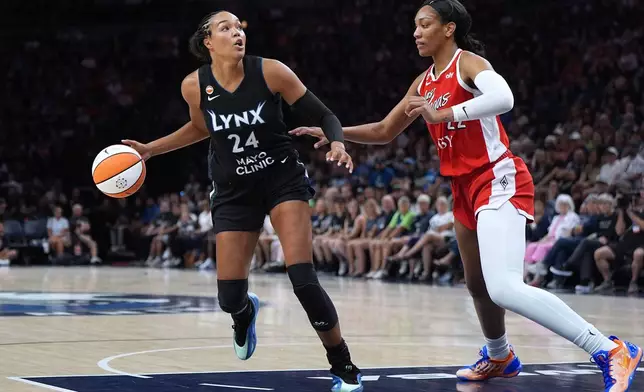 Minnesota Lynx forward Napheesa Collier works toward the basket as Las Vegas Aces center A'ja Wilson defends during the first half of a WNBA basketball game in Minneapolis, Saturday, Aug. 8, 2026. (AP Photo/Abbie Parr)