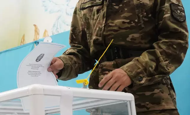 A Kazakhstan's soldier casts his ballot at a polling station during early parliamentary elections in Almaty, Kazakhstan, Sunday, Aug. 23, 2026. (AP Photo/Vladimir Tretyakov)