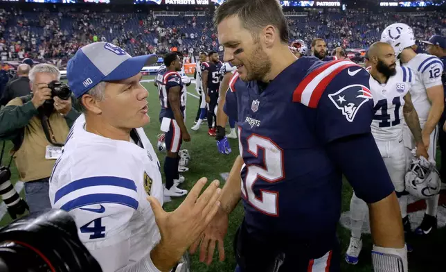 FILE - Indianapolis Colts kicker Adam Vinatieri, left, and New England Patriots quarterback Tom Brady speak at midfield after an NFL football game in Foxborough, Mass., Oct. 4, 2018. (AP Photo/Steven Senne, File)