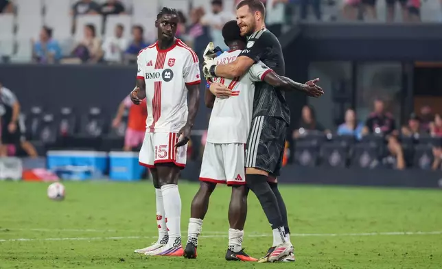 Toronto FC goalkeeper Luka Gavran (1) defenders Richie Laryea (22) and Nicksoen Gomis (15) celebrate after defeating Inter Miami in an MLS soccer game on Saturday, Aug. 22, 2026, in Miami. (AP Photo/David Santiago)