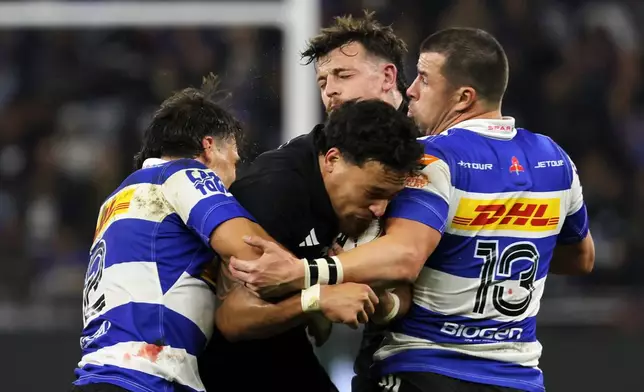 All Blacks' Billy Proctor, center, is being tackled by Stormers' Jonathan Roche, left, and his captain Ruhan Nel during a friendly rugby match between Stormers and All Blacks, in Cape Town, South Africa, Friday, Aug. 7, 2026. (AP Photo/Halden Krog)