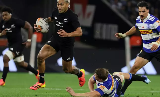 All Blacks' Rieko Ioane, center, breaks away from the Stormers' players during a friendly rugby match between Stormers and All Blacks, in Cape Town, South Africa, Friday, Aug. 7, 2026. (AP Photo/Halden Krog)